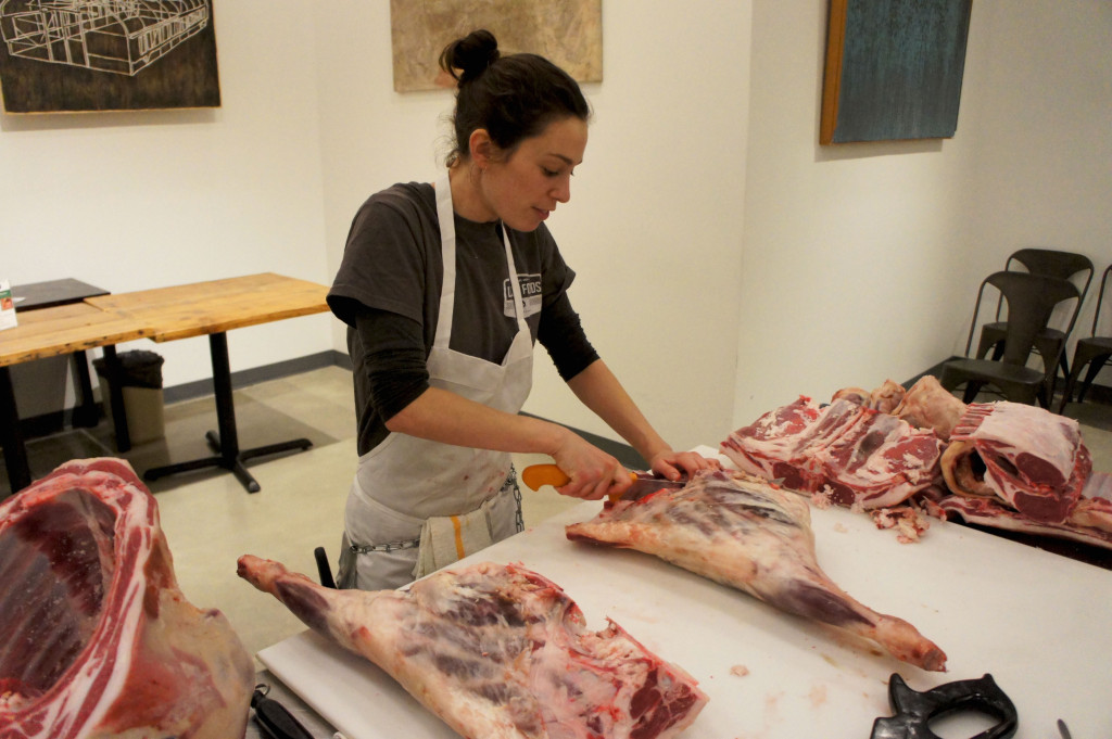 Meat cutting classes are an important part of the consumer information efforts by Chicago's The Butcher & Larder. Here McCullough Kelly-Willis, a staff butcher who conducted a March 15 class on cutting down a whole lamb, trims the legs.