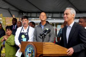 Chicago Mayor Rahm Emanuel spoke at the Opening Day ceremony for the Whole Foods Englewood store. He led the city's efforts to persuade Whole Foods Co-CEO Walter Robb (grey jacket) and Midwest President Michael Bashaw (white shirt) to locate the store in the economically challenged community.